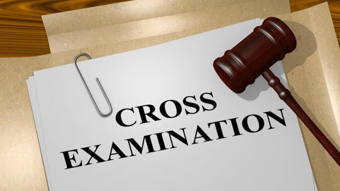 3D rendering of a gavel sitting on a piece of paper stating "Cross Examination" in large block letters